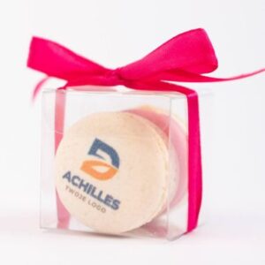 Dwa makaroniki z logiem w pudełku z czerwoną wstążką